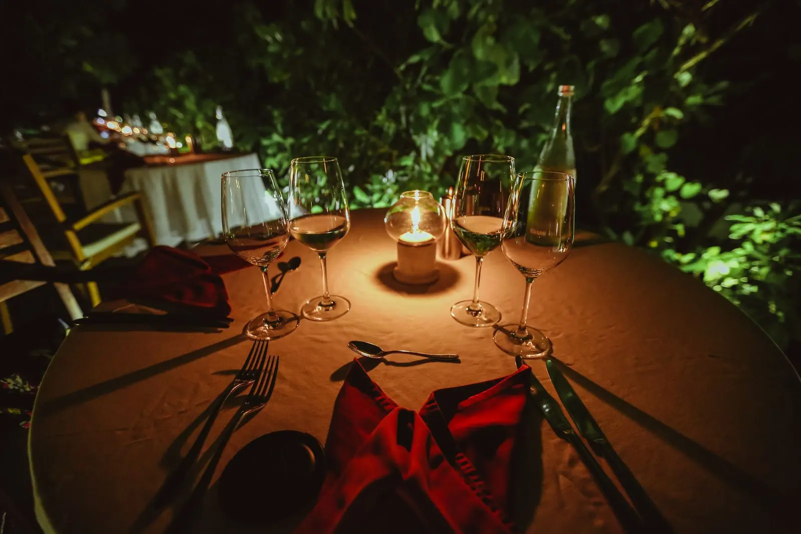Une table dressée au crépuscule, les chandelles allumées.