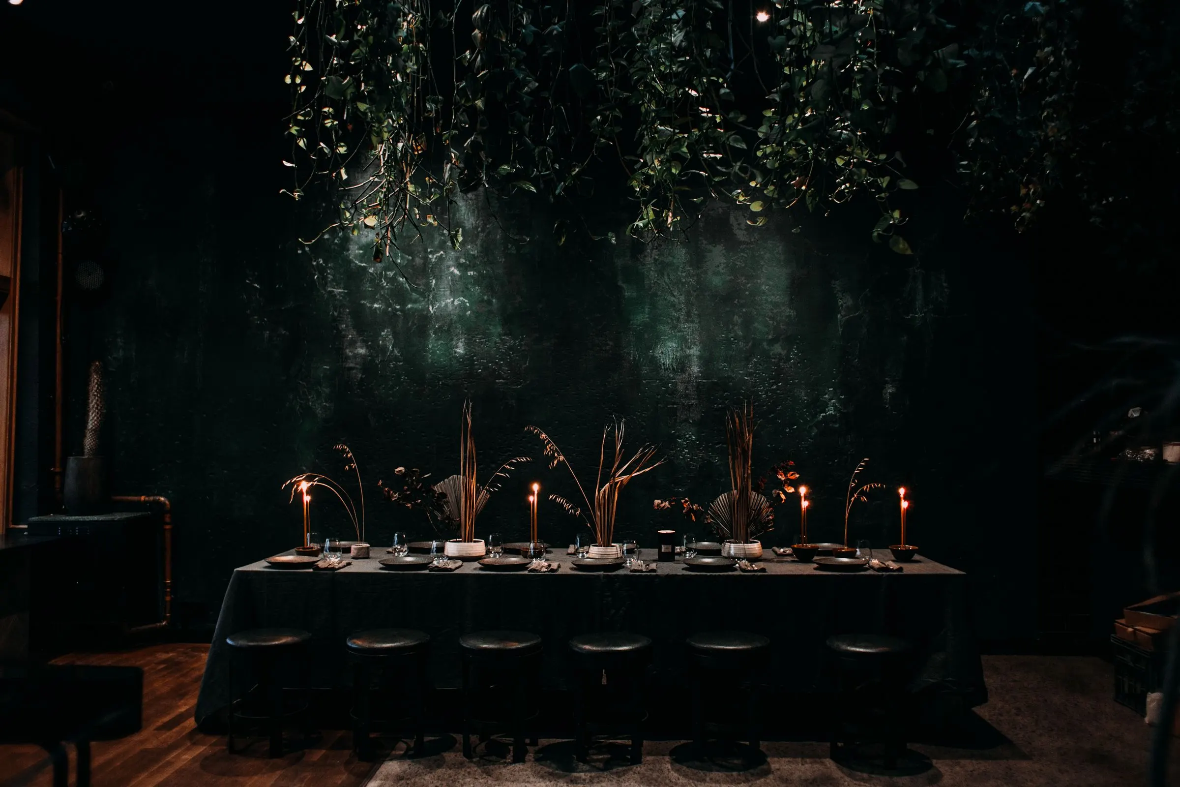 La longue table du soir, dressée sous les branches, à la lueur des chandelles.